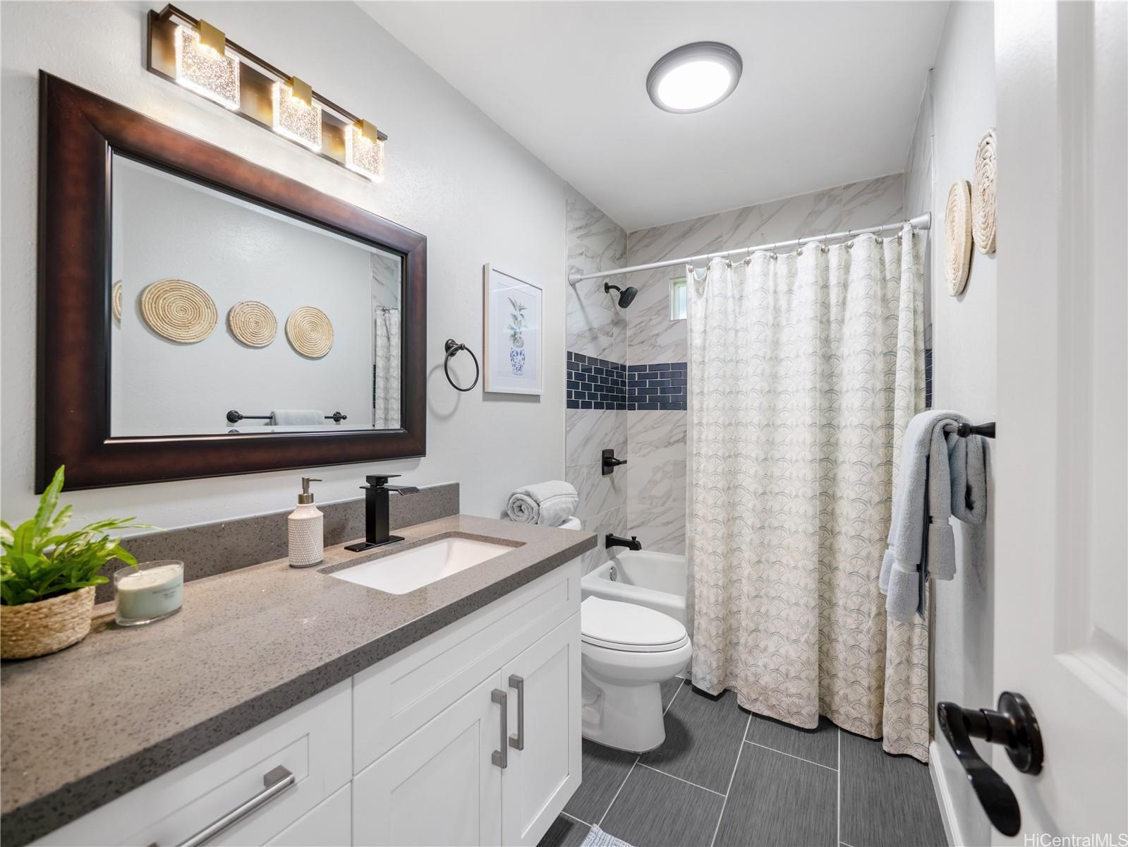 Updated full bathroom with quartz vanity and tiled shower