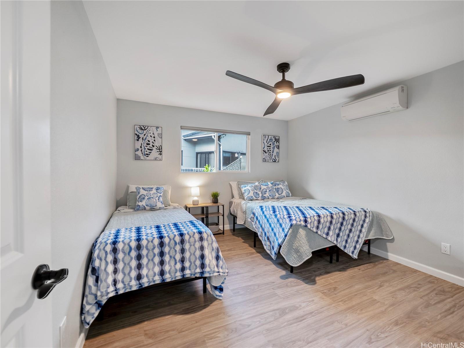 Bedroom with two beds and coastal artwork