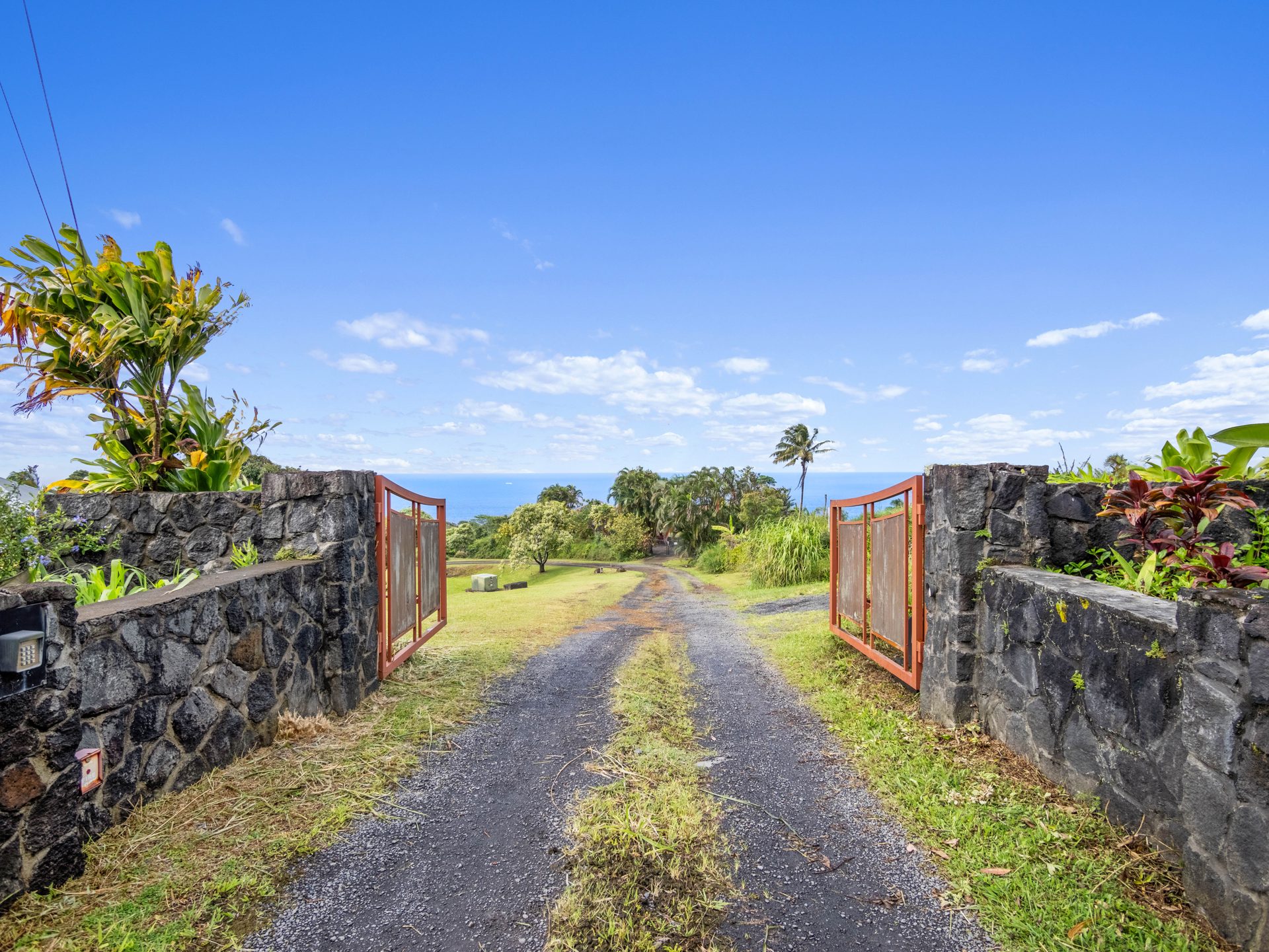 Entry road between lava rock walls with ocean beyond