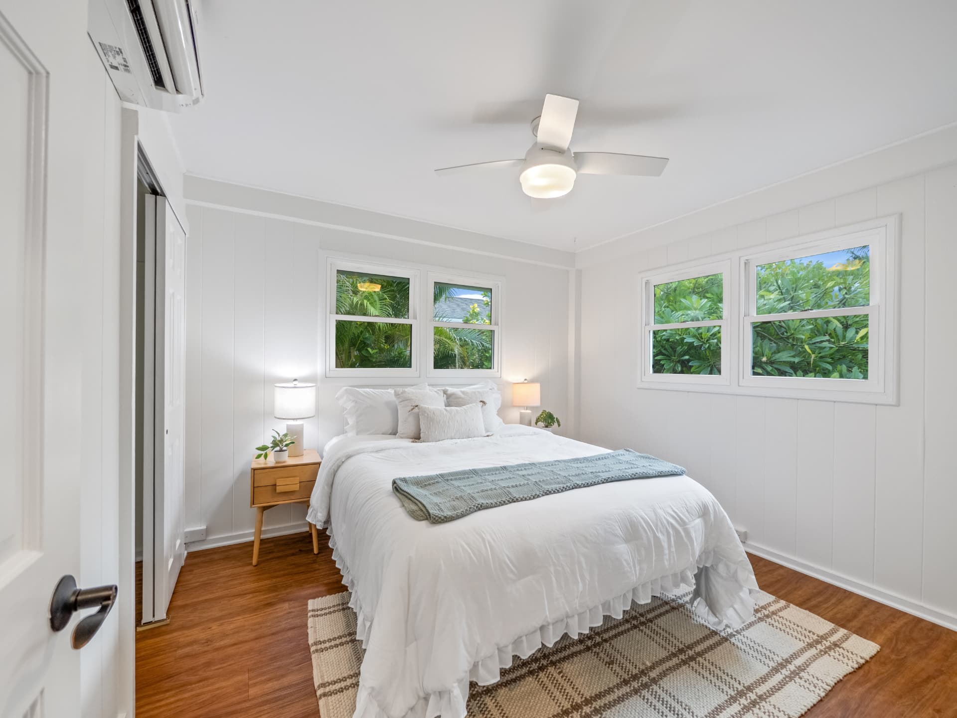 Guest bedroom with white bedding and garden windows